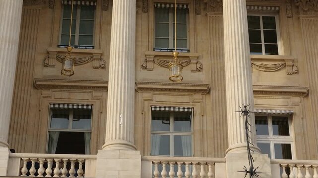 Close up of neoclassical palace facade with columns, windows, and decorative elements in Paris