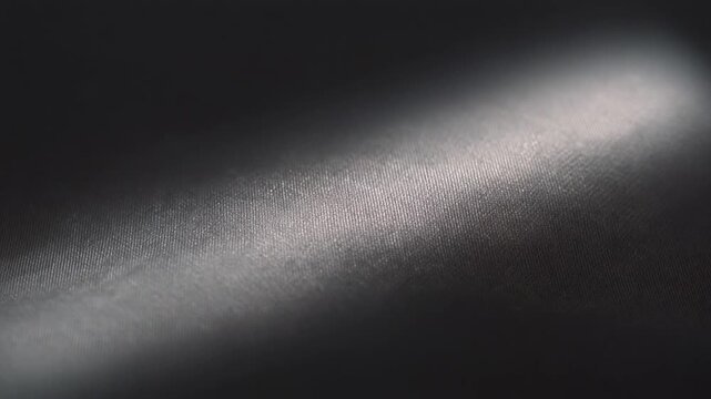 Satin sheet surface with light sweeping slowly across the surface