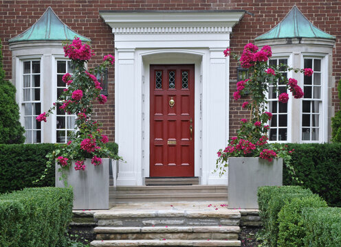 Front door of brick house with purple bougainvillea flowers
