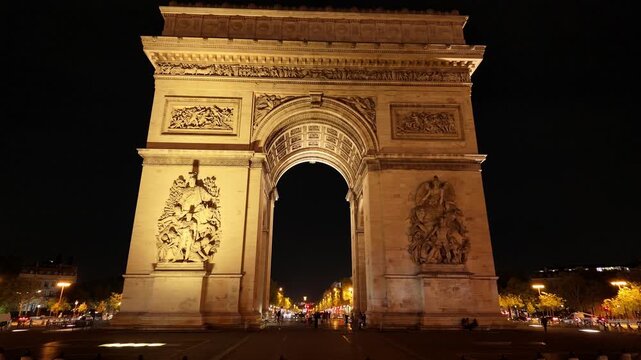 Arc de Triomphe standing brightly lit against the dark night sky