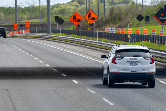 Gaspesie, Canada, 30 May 2026 : A white GMC Terrain SUV drives on a highway with multiple road work and speed limit signs.