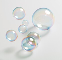 Obraz premium Colorful soap bubbles floating against white background
