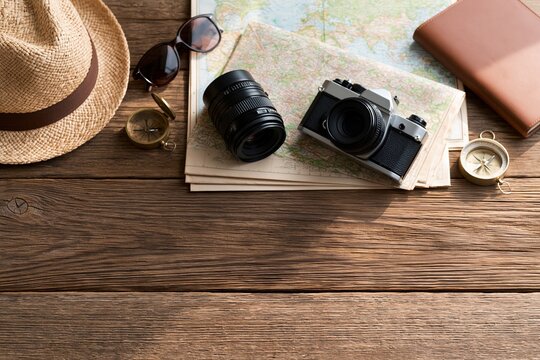 Vintage camera and travel accessories on wooden table