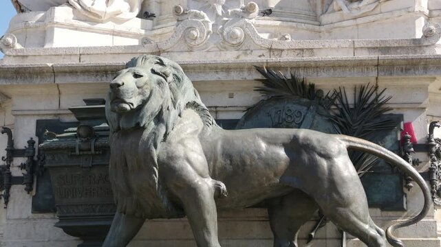 Bronze lion sculpture guarding the Monument a la Republique on a sunny day