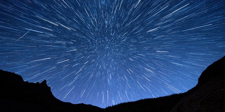 Long exposure night sky star trails over dark