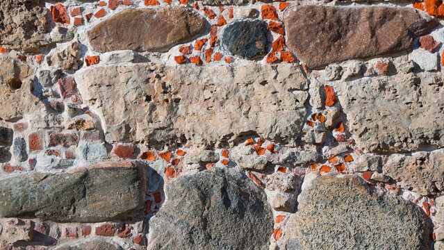 The photo shows a wall made of old brick and stone