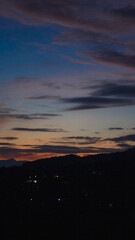 Fototapeta premium A striking, vertical landscape photograph capturing the serene transition from dusk to night. The expansive sky dominates the upper portion of the frame