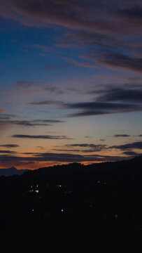 A striking, vertical landscape photograph capturing the serene transition from dusk to night. The expansive sky dominates the upper portion of the frame