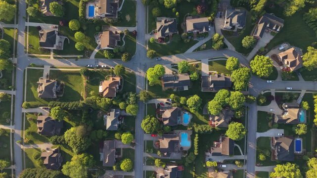 Aerial perspective of suburban neighborhood in Johnson City, Tennessee, featuring various residential homes, green lawns, swimming pools, with tree-lined streets and organized layouts clearly visible