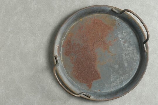 Empty rectangular tin plate or tray on a neutral grey background, top-down view mockup with rustic metallic texture 