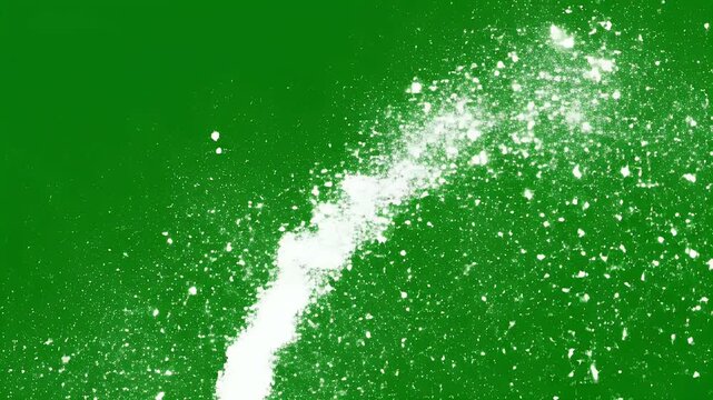 White powder exploding outward in a dynamic arc against a solid green background