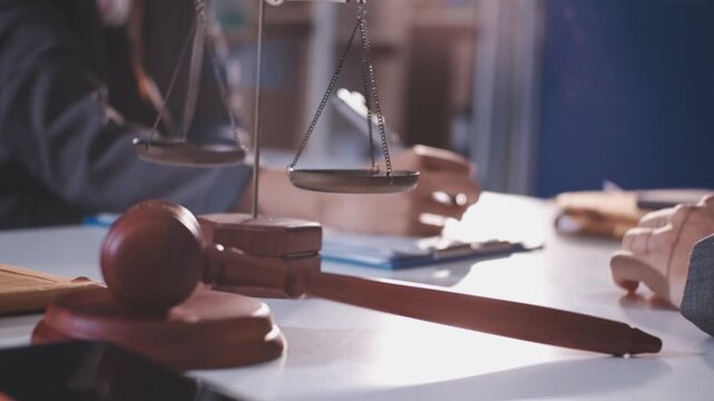 Close-up of judge gavel and scales of justice on lawyer desk.