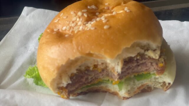 Close Up View of Eating Freshly Made Burger with Lettuce and Cheese