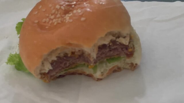 Tasty Fast Food Beef Burger Bitten on White Paper Towel