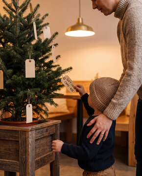Parent and child decorating a charity gift tree