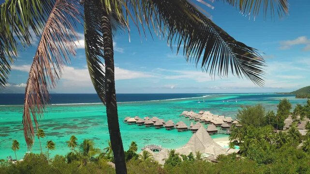 French Polynesia travel background. Overwater bungalows at luxury Moorea resort overlooking a turquoise lagoon, white sand beach and swaying palm trees under a clear blue sky, idyllic tropical getaway