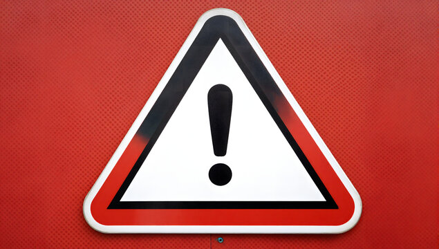 Warning Sign of Danger: A prominent warning triangle sign with an exclamation mark, set against a textured red background, signifies caution and alerts to potential hazards.