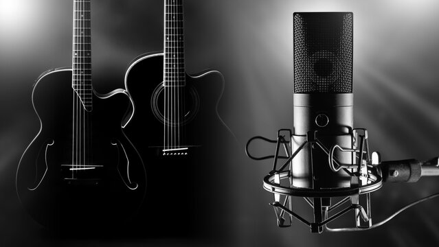Music recording studio. Audio production. Professional condenser microphone and acoustic guitars are prepared for music recording, podcasting and sound production sessions.
