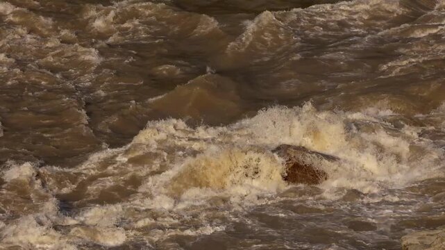 Close-up video of the Beas River in Mandi, Himachal Pradesh, India, flowing rapidly over natural rocks after heavy monsoon rainfall.