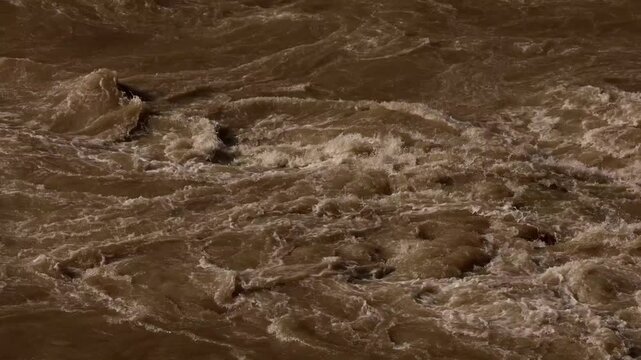 Close-up video showing muddy water moving rapidly through the Beas River during the intense monsoon season in Mandi, Himachal Pradesh, India.