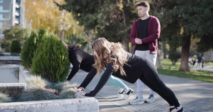 Friends Doing Fitness Exercises in a Public Park, Doing Pushups and High Fives