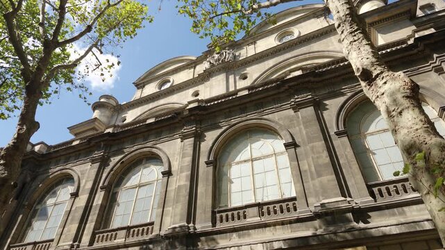 Ornate architecture of a classic Parisian building with trees and blue sky
