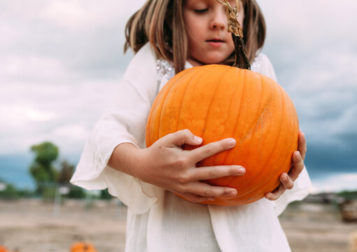 Little Girl Carrying a Pumpkin 