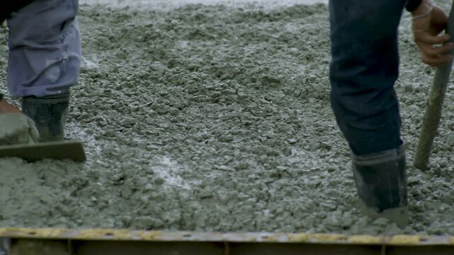 Workers Wading In Fresh Wet Concrete