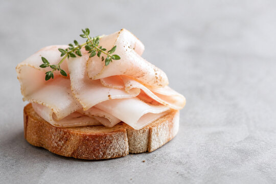 Delicate cured lardo on rustic bread slice