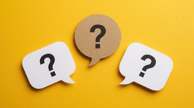 Three speech bubbles with question marks on yellow surface