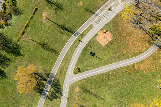 bicycle lane and walking path passing through autumn park. aerial top view.