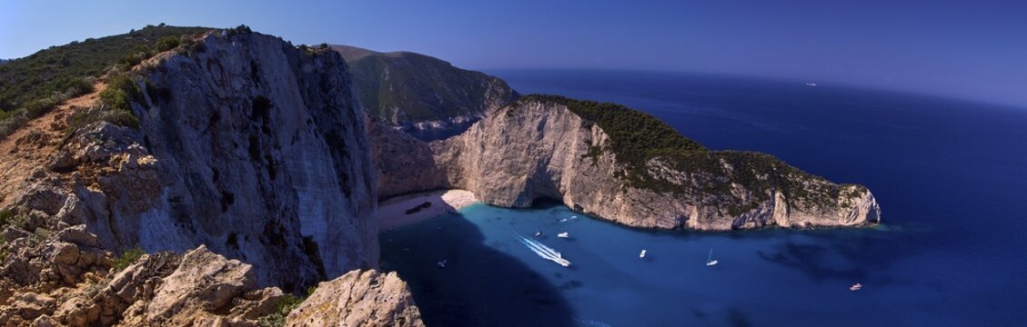 Paralia Navagio, Shipwreck Beach, panoramic photo, rocky cliff, shipwreck MV Panagiotis, excursion boats, blue and turquoise crystal clear sea, cloudless blue sky, Zakynthos, Ionian Islands, Greece