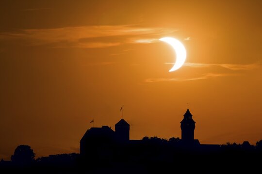 Sky spectacle, astronomical event, solar eclipse, partial solar eclipse over the black silhouette of the Kaiserburg in Nuremberg with the distinctive Sinnwell tower on the right side, Middle Franconia, Bavaria, Germany