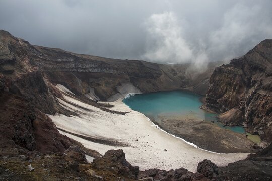 Steaming fumarole with crater lake on the Gorely volcano, Kamchatka, Russia