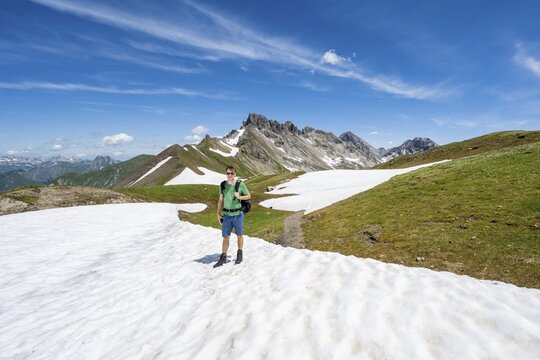 Hiker, mountaineer on the hiking trail, Heilbronner Weg, in the background old snow fields and mountain panorama with summit of Gro&szlig;er Krottenkopf and Ramstallkopf, Allg&auml;u Alps, Allg&auml;u, Bavaria, Germany