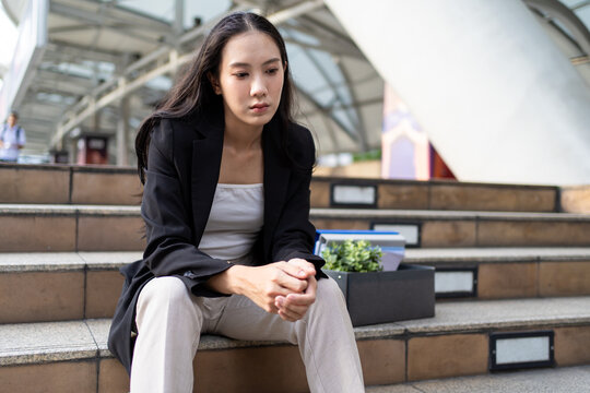 Asian businesswoman feeling sad and discouraged after losing her job. 