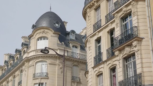 Haussmann style buildings showing ornate balconies and a distinct domed roof in Paris