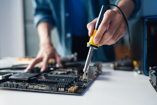 IT Engineer Installing Computer Hardware Equipment and Maintaining Motherboard Components in Professional Electronic Repair Facility.