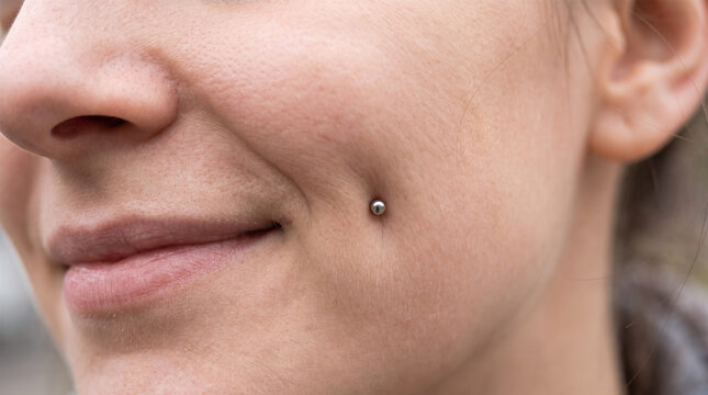 Close Up of Smiling Woman Cheek with Silver Dermal Anchor Dimple Piercing