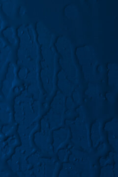 Branching water trails on a dark blue vertical background with small droplets.