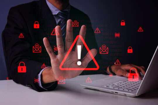 Businessman Raising Palm Open Hand to Stop Holographic Cyber Threat Warning Beside Laptop
