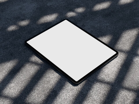 Tablet with blank white screen mockup on textured ground with shadow overlay