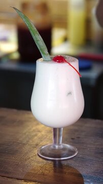 Preparaci&oacute;n de pi&ntilde;a colada con guarnici&oacute;n de cerezas y canela molida espolvoreada