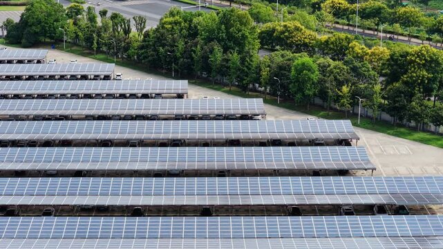 Aerial view of solar panel carports beside a tree lined road