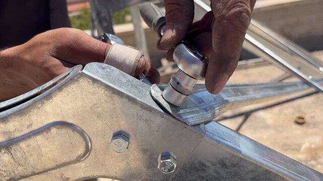  Worker Using Ratchet Socket Wrench to Assemble Solar Water Heater Frame