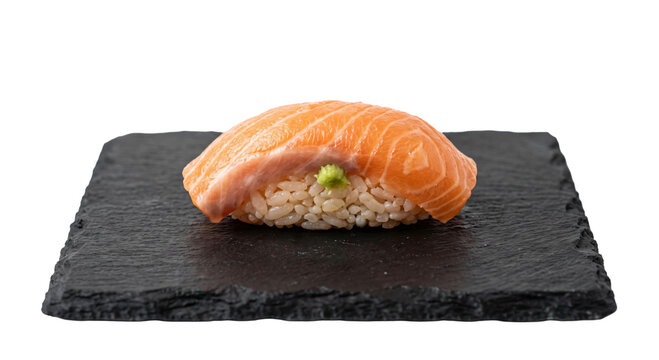 Fresh salmon nigiri sushi with wasabi on a dark slate plate