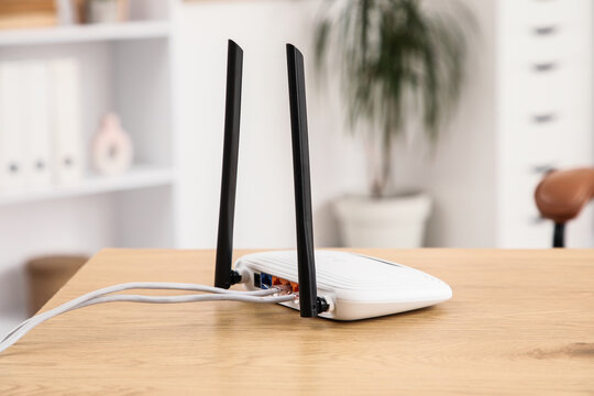 High speed internet connectivity and digital communication, wireless router with ethernet cables on a wooden desk in a modern home office environment