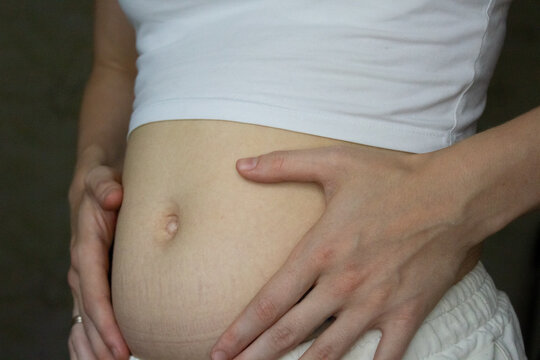 Woman touching bloated belly close up stomach ache indigestion or early pregnancy concept