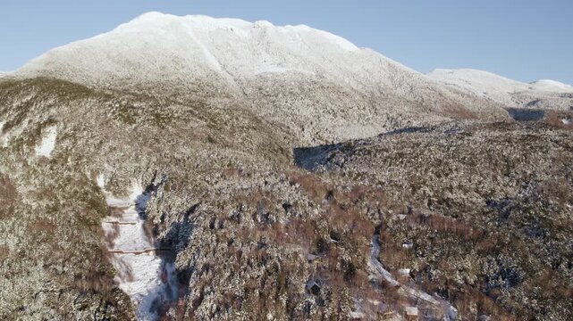Aerial View Over Snow Covered Mountain Forest In Winter