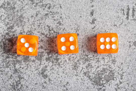 Orange game dices on grey background